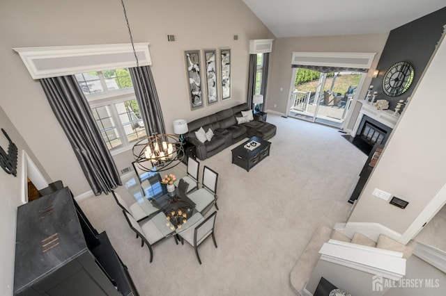 carpeted living area with an inviting chandelier, baseboards, and a wealth of natural light