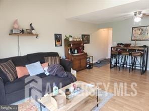 living room with wood-type flooring and ceiling fan