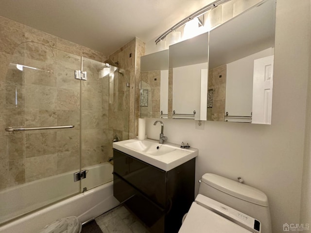 full bathroom featuring vanity, toilet, and bath / shower combo with glass door