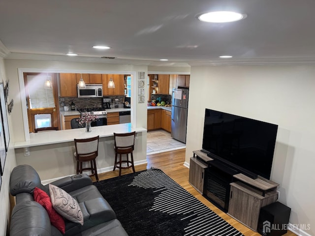 living room with light hardwood / wood-style flooring and crown molding