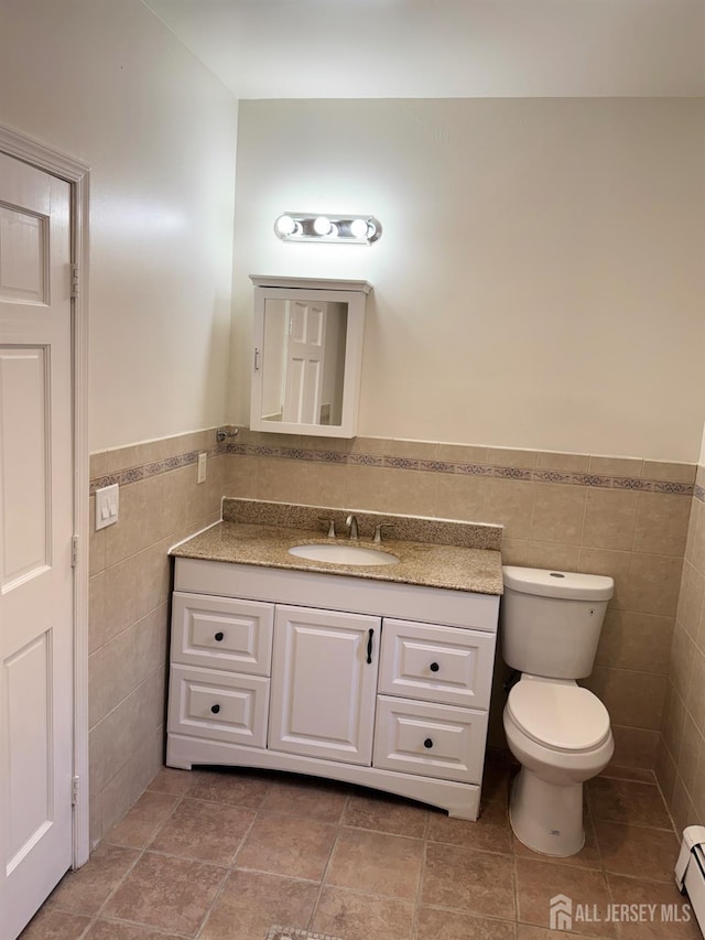 360 Alpine St, Perth Amboy, NJ 08861 - half bath with tile walls, vanity, a baseboard heating unit, and a wainscoted wall