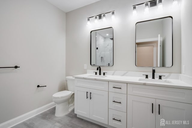 bathroom with baseboards, walk in shower, toilet, and a sink