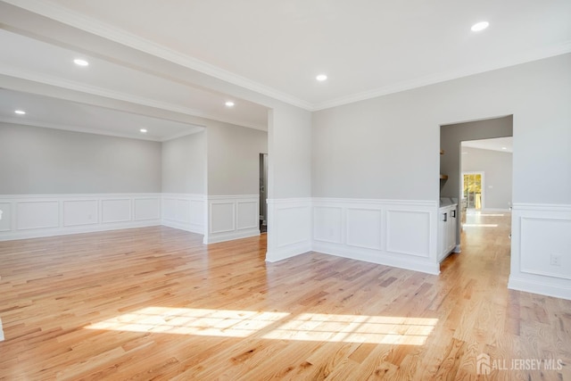 unfurnished room with a decorative wall, light wood-style flooring, wainscoting, and recessed lighting