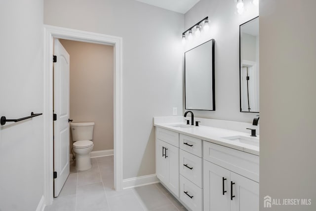 bathroom with tile patterned floors, double vanity, toilet, and a sink