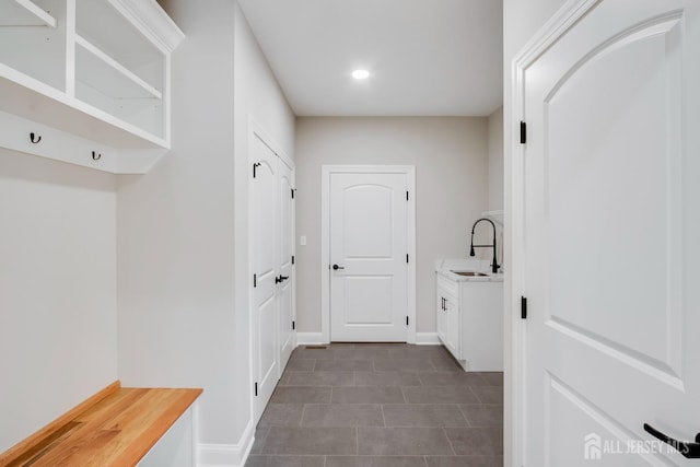 mudroom with baseboards, dark tile patterned flooring, recessed lighting, and a sink