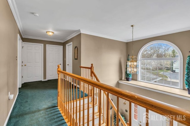 hall featuring baseboards, ornamental molding, dark colored carpet, and an upstairs landing