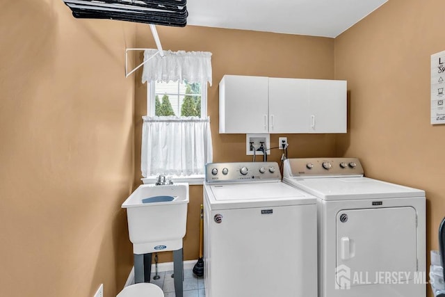 laundry room featuring separate washer and dryer, cabinet space, a sink, and tile patterned floors