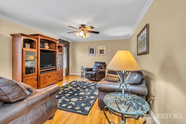 living area with ceiling fan, baseboards, ornamental molding, and light wood-style flooring