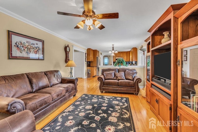 living area with light wood-style flooring, crown molding, and ceiling fan