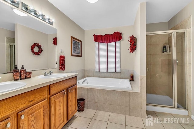 bathroom featuring tile patterned floors, a stall shower, and a sink