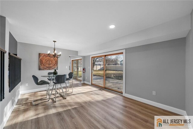 dining area featuring hardwood / wood-style floors and a notable chandelier