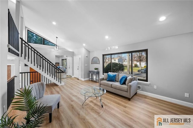 living room featuring high vaulted ceiling and light hardwood / wood-style flooring