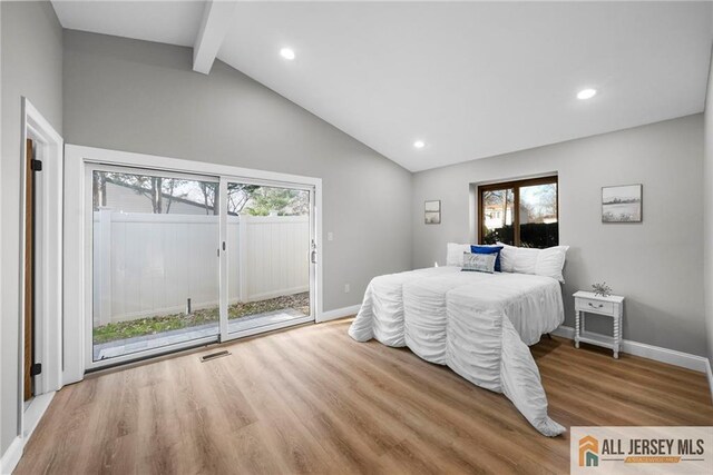 bedroom with hardwood / wood-style floors, lofted ceiling with beams, and access to outside