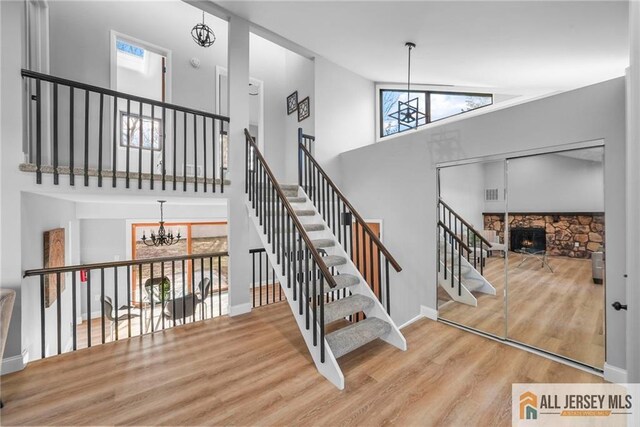 staircase featuring plenty of natural light, a fireplace, and a chandelier