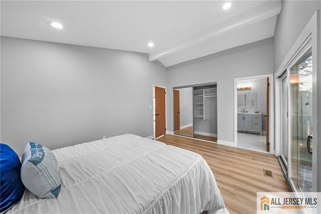 bedroom featuring ensuite bathroom, lofted ceiling with beams, wood-type flooring, and a closet