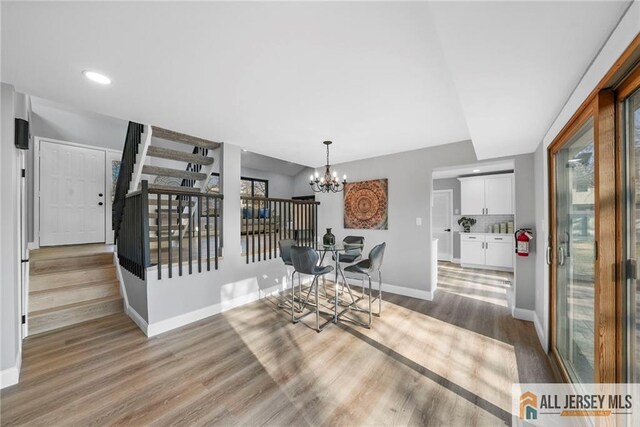 dining area with hardwood / wood-style flooring and a notable chandelier