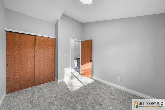 unfurnished bedroom with carpet floors and a closet