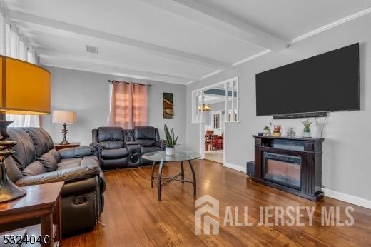 living room with a fireplace, hardwood / wood-style floors, and beamed ceiling