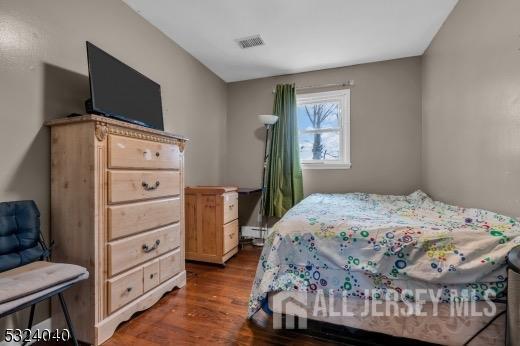 27 6th Ave, Port Reading, NJ 07064 - bedroom featuring dark wood finished floors and a baseboard heating unit