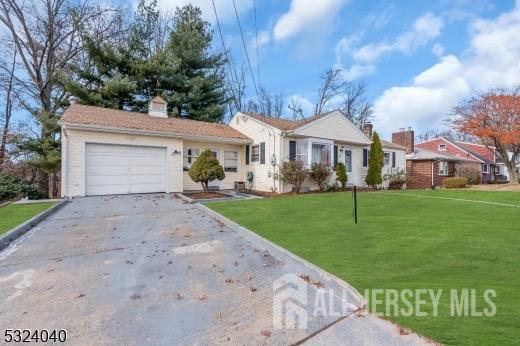 ranch-style home with a garage and a front lawn