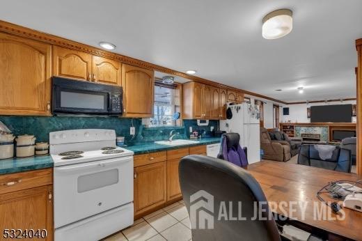 kitchen with sink, light tile patterned floors, and white appliances