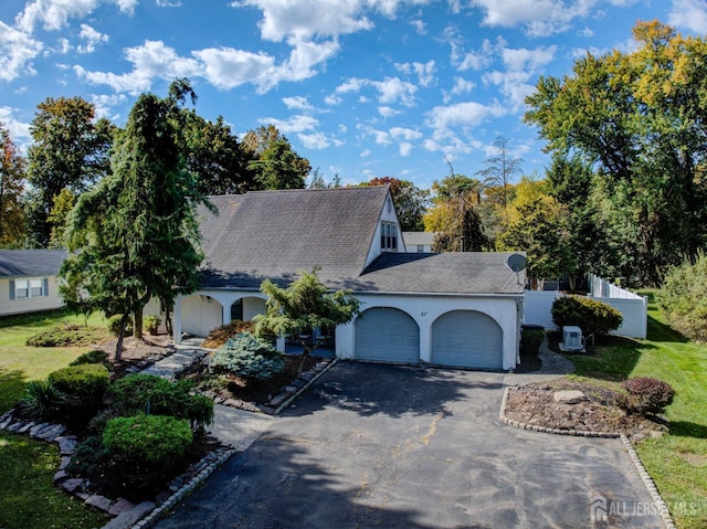 view of property exterior with a yard, an attached garage, driveway, and stucco siding
