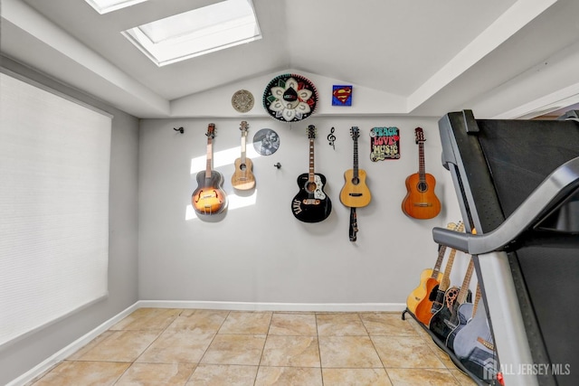rec room with tile patterned floors, baseboards, and lofted ceiling with skylight