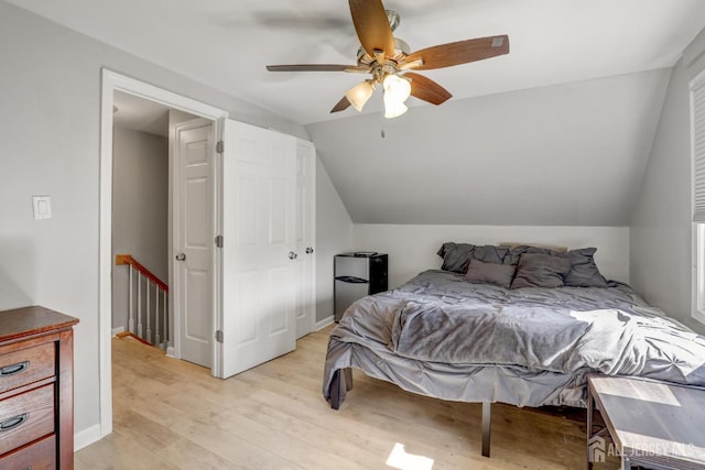 bedroom featuring light wood-type flooring, a ceiling fan, baseboards, and lofted ceiling