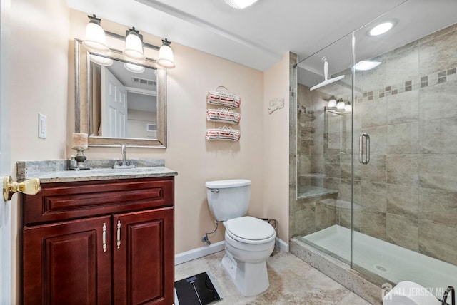bathroom with a stall shower, vanity, baseboards, tile patterned floors, and toilet