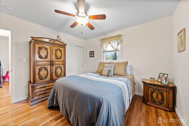 bedroom with baseboards, light wood finished floors, ceiling fan, and a closet