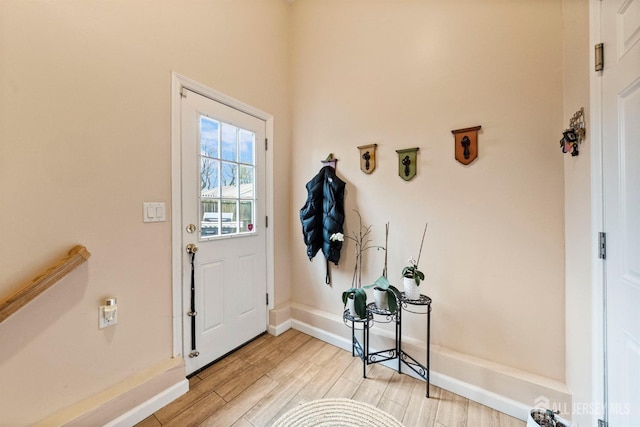 doorway to outside with baseboards and light wood-style flooring