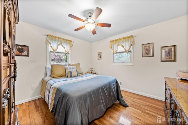 bedroom featuring baseboards, ceiling fan, and light wood-style floors