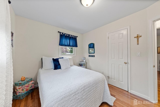bedroom featuring baseboards and wood finished floors