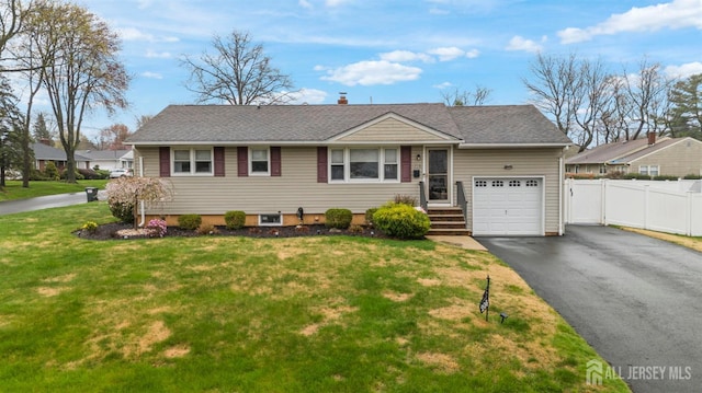 view of front of house with aphalt driveway, fence, a front yard, and a garage