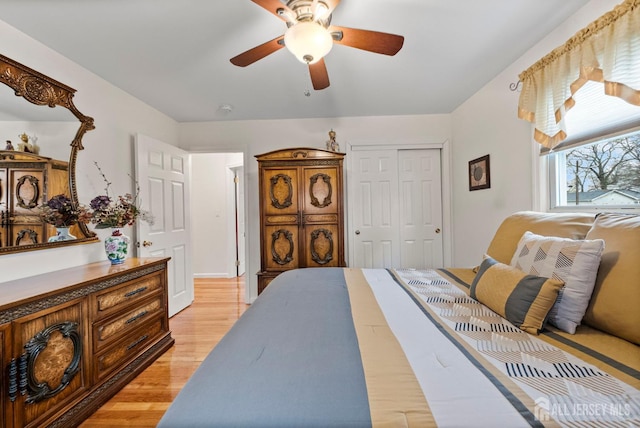bedroom with a ceiling fan, a closet, and light wood-type flooring