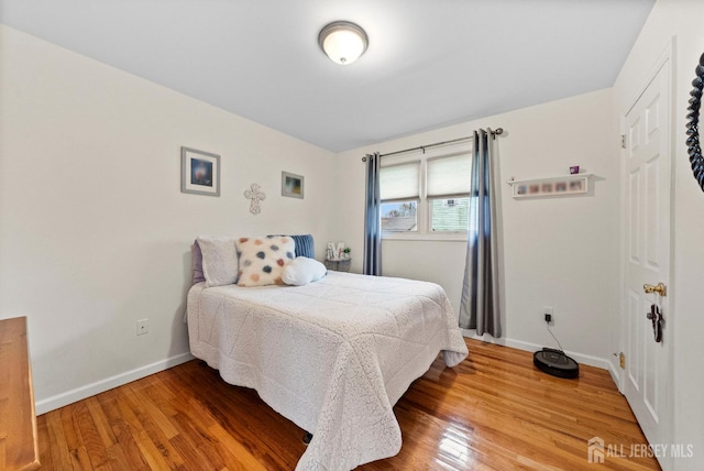 bedroom with baseboards and wood finished floors