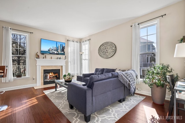 living room with dark wood-type flooring and a tiled fireplace