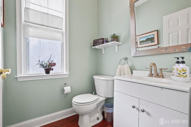 bathroom featuring hardwood / wood-style flooring, toilet, and vanity