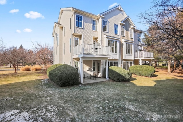 view of front of house with a patio, a front lawn, and a balcony