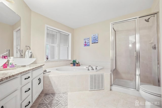 full bathroom with plus walk in shower, vanity, tile patterned flooring, and toilet