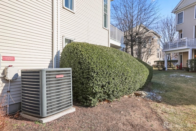 exterior details featuring central AC unit and a lawn