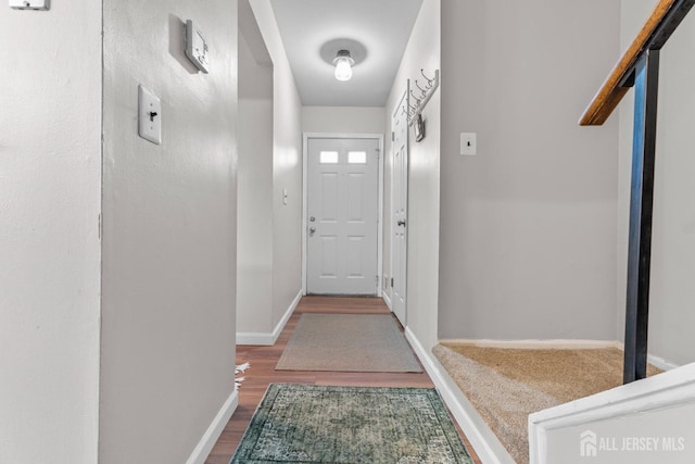 doorway to outside featuring baseboards and wood finished floors