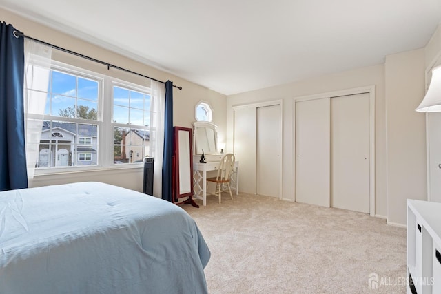 carpeted bedroom featuring two closets