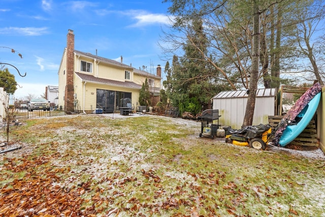 rear view of property with a patio, a fenced backyard, a chimney, a storage unit, and an outdoor structure