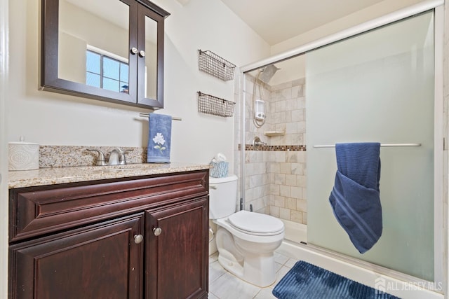 bathroom featuring vanity, a shower stall, toilet, and tile patterned floors