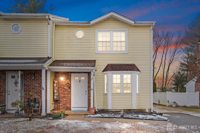 view of front facade with fence and brick siding