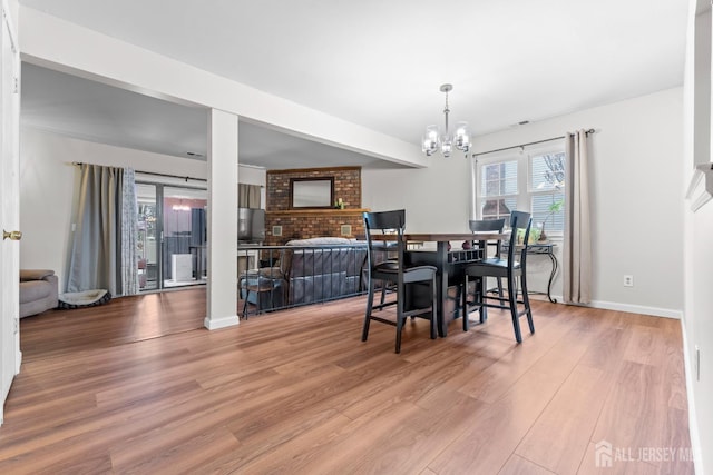 dining area featuring a notable chandelier, baseboards, and wood finished floors