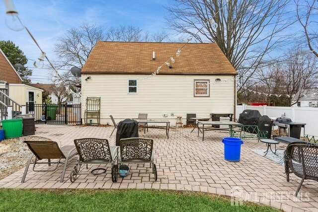 rear view of house featuring fence and a patio area