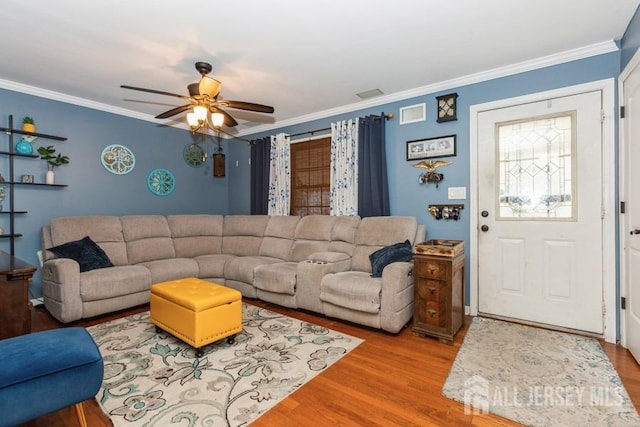 living room featuring crown molding, visible vents, wood finished floors, and a ceiling fan