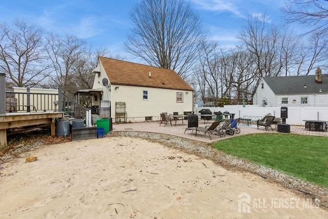 rear view of property with a patio area, a deck, fence, and a yard